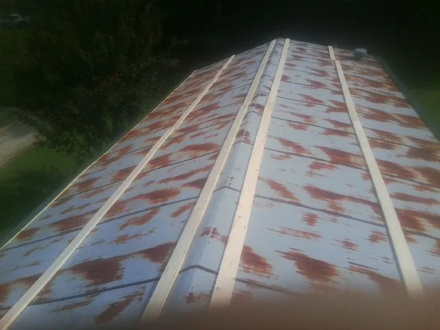 Rusted metal roof panels with new wood purlins before replacement — Storm Damage Roof Repair in Creola by Roofing Brothers