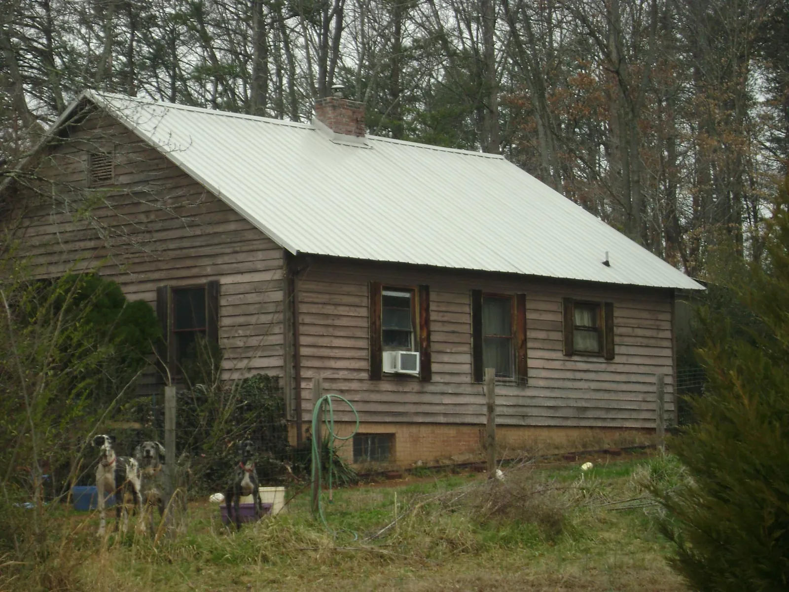 White metal roof on an old wood sided farmhouse, from a Metal Roof Installation job in Creola